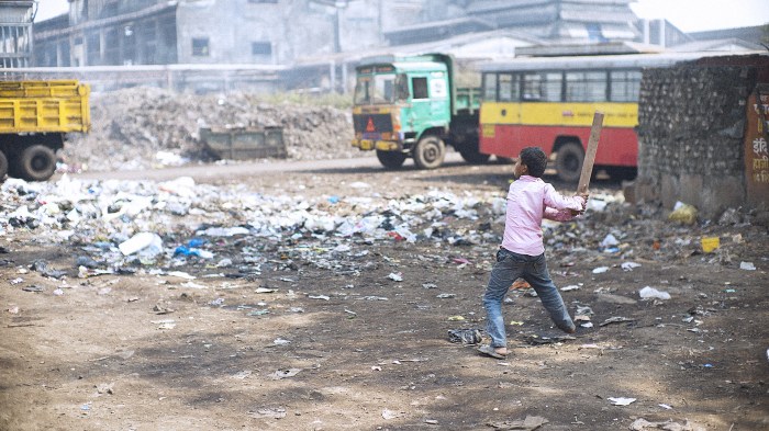 Menino em meio ao lixo. Foto de gary yim via Shutterstock.com